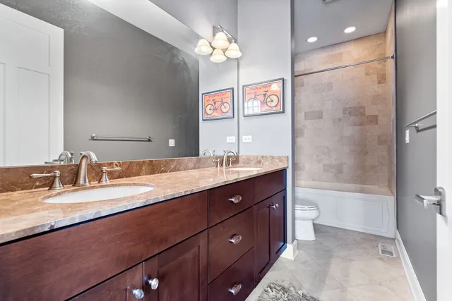 a bathroom with a granite countertop sink a toilet a mirror and shower