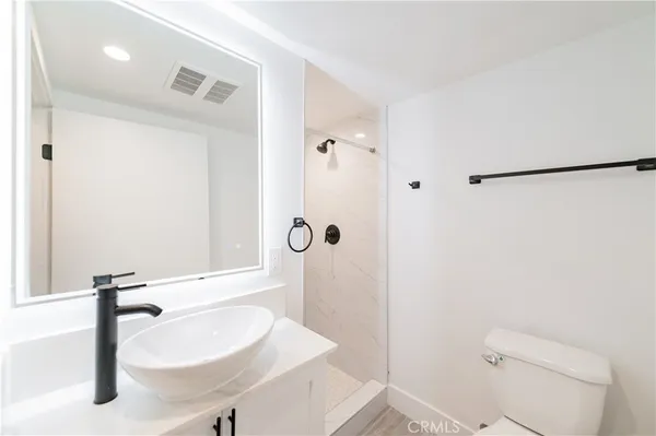 a bathroom with a sink a toilet and shower