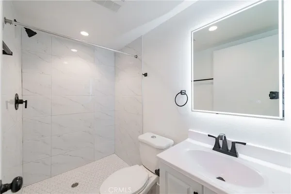 a bathroom with a sink a toilet and shower