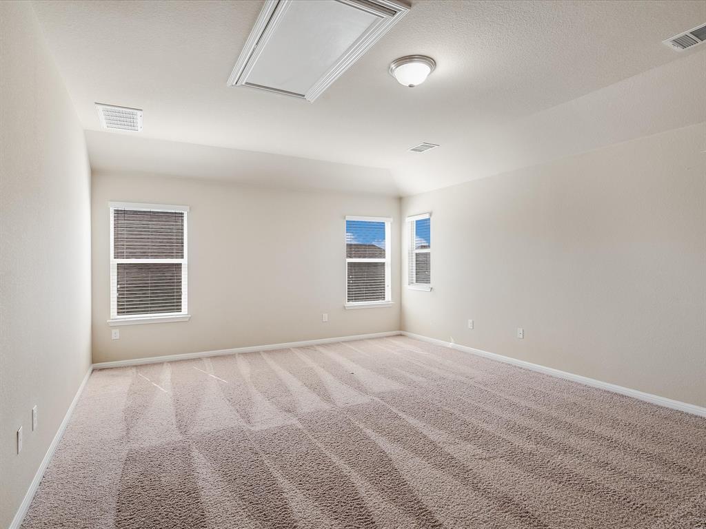 141 Serrano Street Georgetown, TX 78628 - Photo 5 of 7 An airy bedroom with vaulted ceilings and abundant natural light.