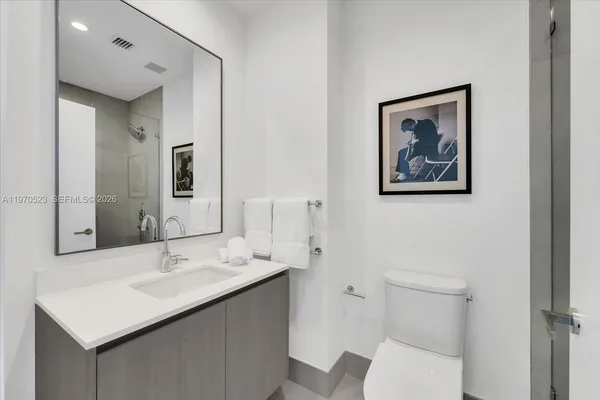 a bathroom with a sink mirror and toilet