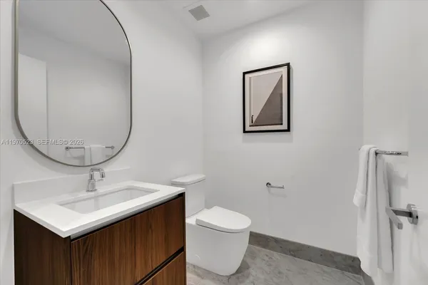 a bathroom with a sink mirror and toilet