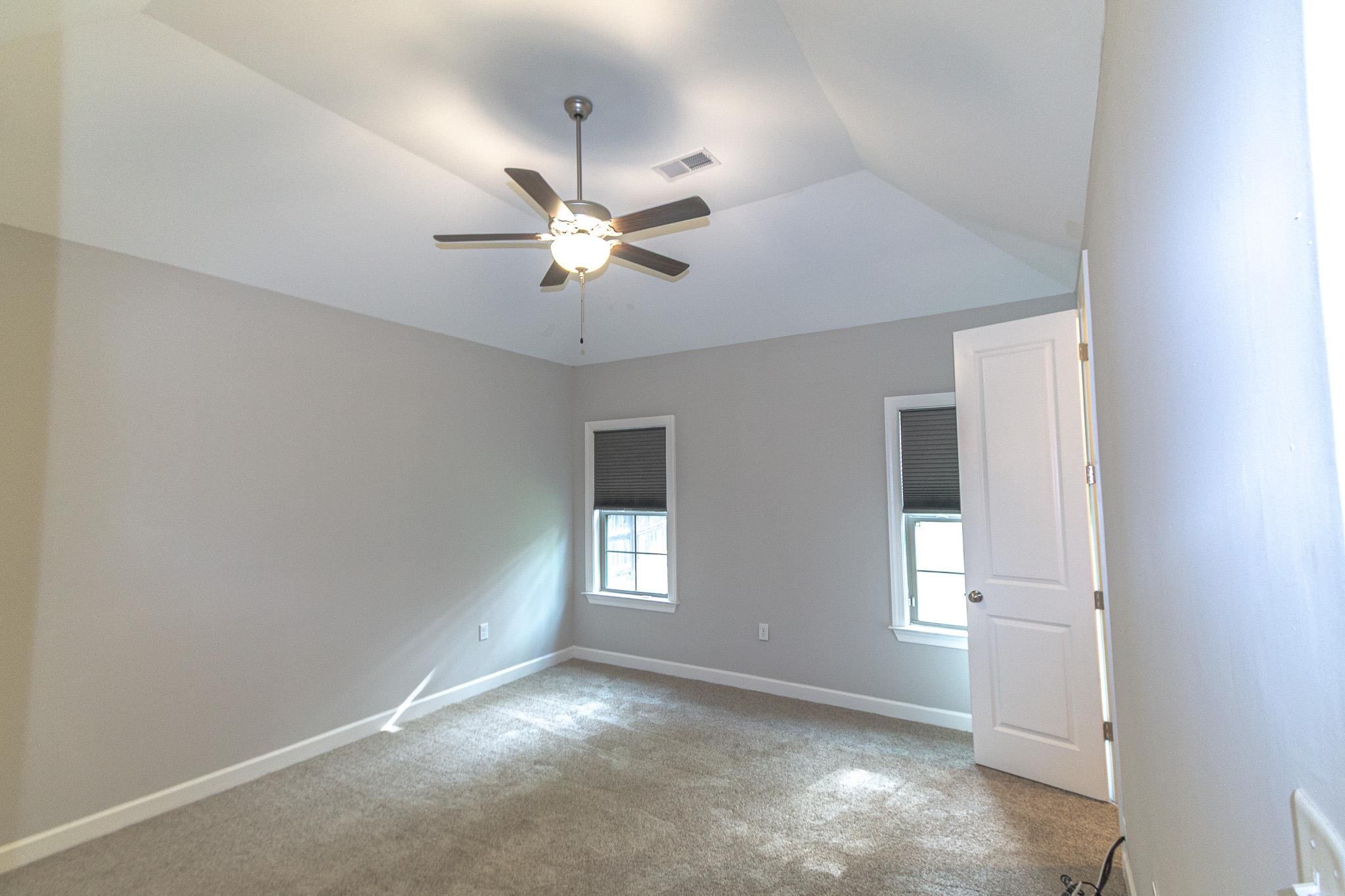2422 Crimson Ridge Lane Cordova, TN 38016 - Photo 13 of 36 Empty room featuring a ceiling fan, light carpet, and vaulted ceiling