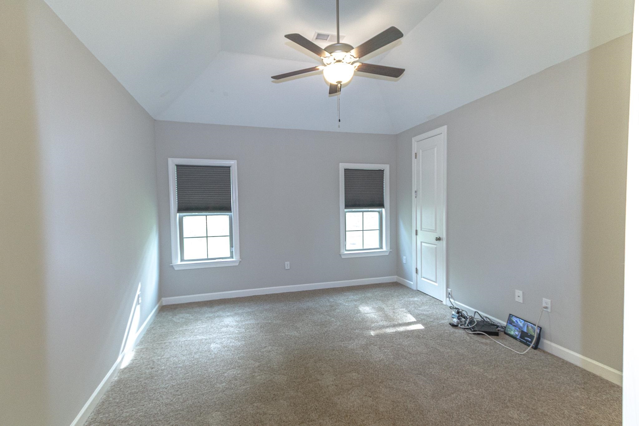 2422 Crimson Ridge Lane Cordova, TN 38016 - Photo 15 of 36 Empty room with ceiling fan, light colored carpet, and lofted ceiling