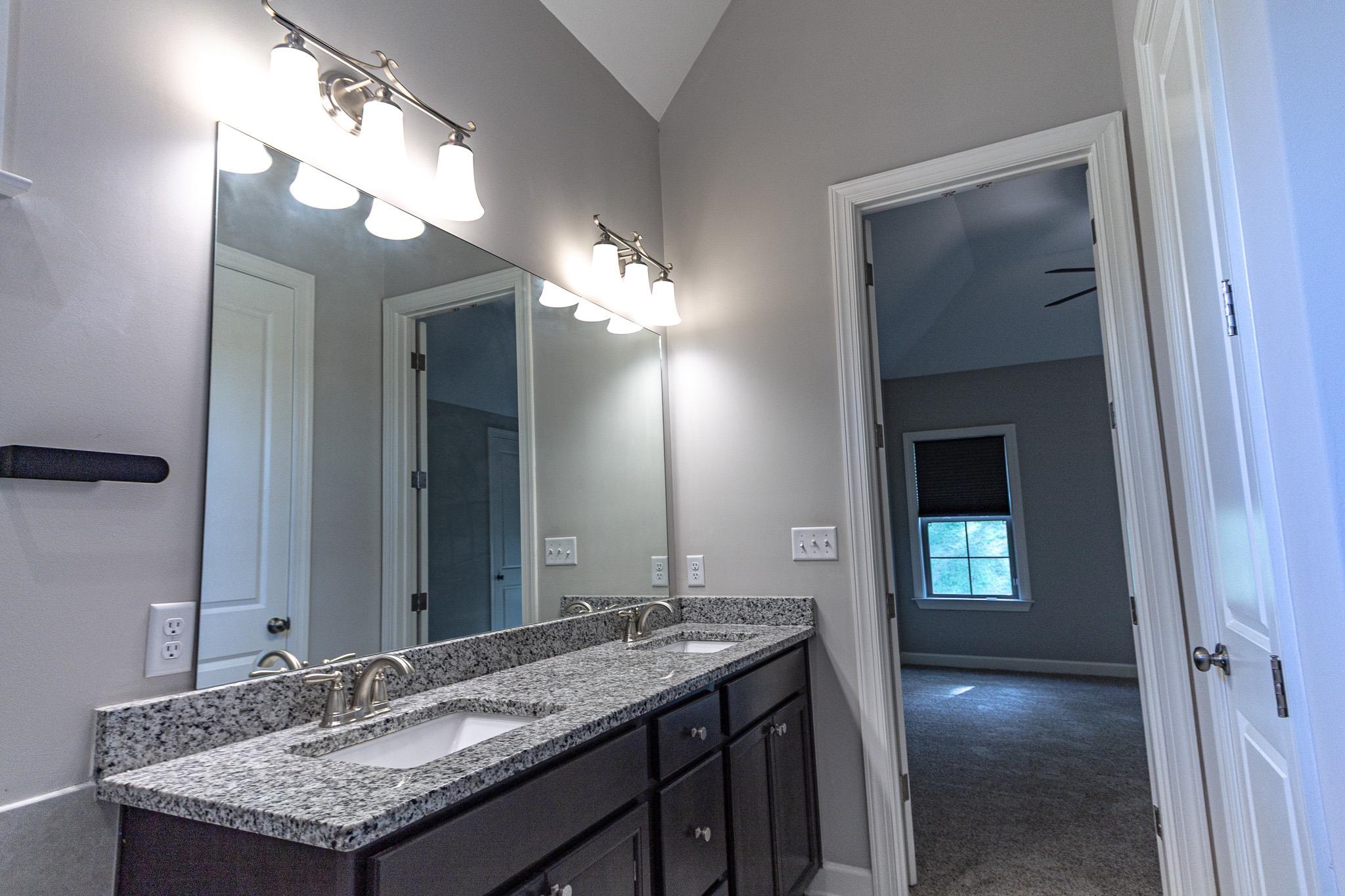 2422 Crimson Ridge Lane Cordova, TN 38016 - Photo 19 of 36 Full bathroom with double vanity, dark colored carpet, and vaulted ceiling