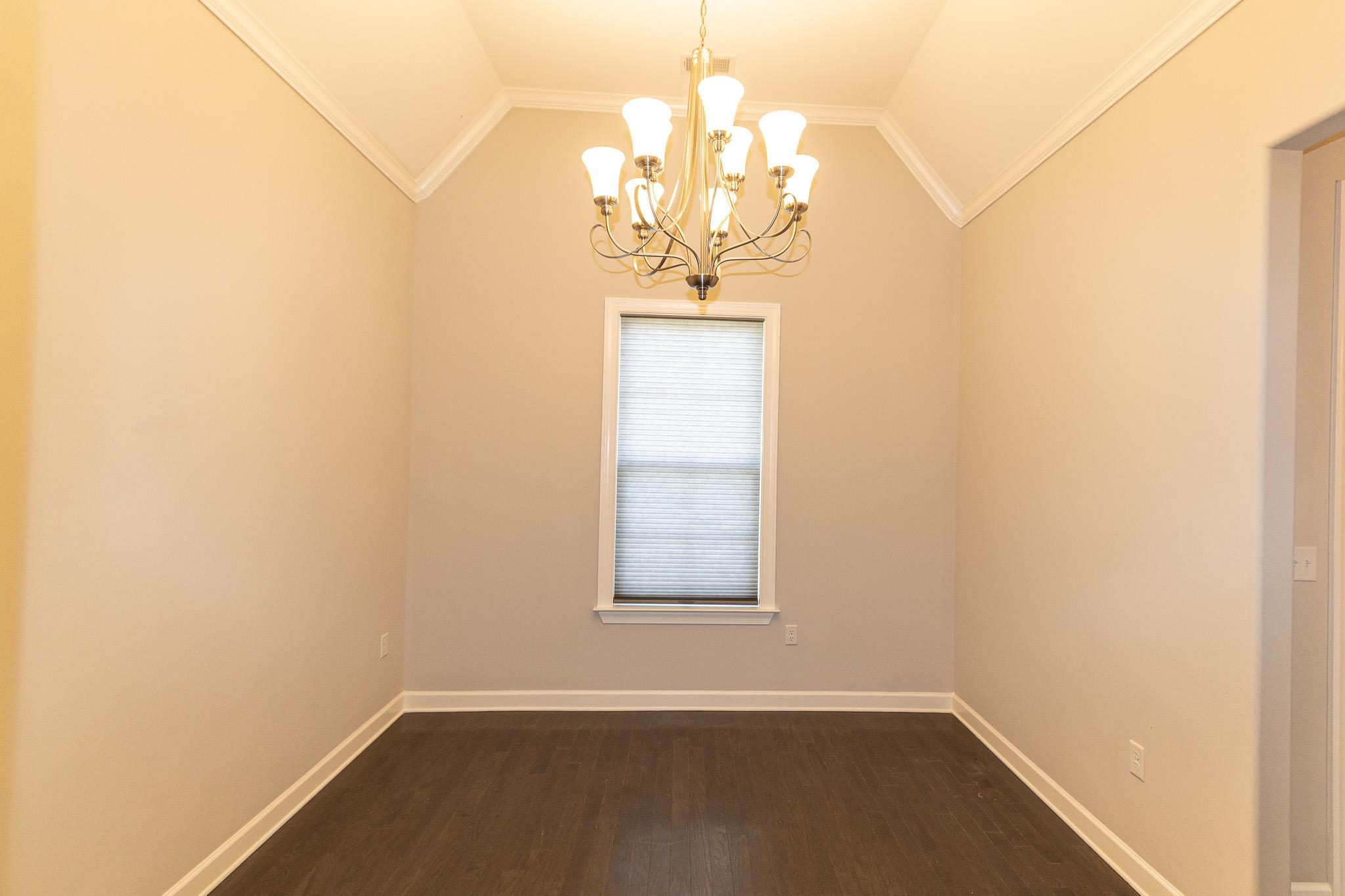 2422 Crimson Ridge Lane Cordova, TN 38016 - Photo 2 of 36 Spare room with ornamental molding, a chandelier, dark wood-style flooring, and lofted ceiling