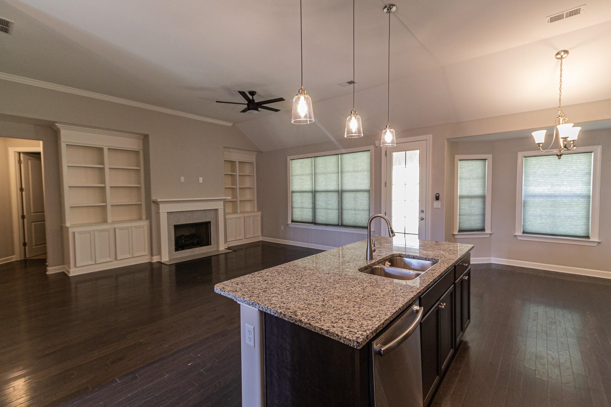 2422 Crimson Ridge Lane Cordova, TN 38016 - Photo 36 of 36 Kitchen featuring lofted ceiling, dark wood-style floors, open floor plan, an island with sink, and light stone countertops