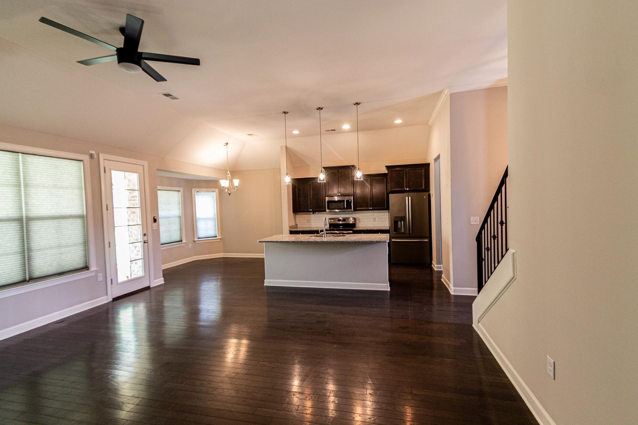 2422 Crimson Ridge Lane Cordova, TN 38016 - Photo 5 of 36 Kitchen featuring suspended lighting, dark wood finish cabinets, stainless steel appliances, a kitchen island with sink, and dark wood-style floors