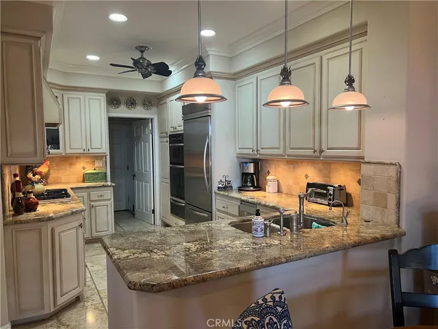 a kitchen with stainless steel appliances granite countertop a sink a stove and a refrigerator