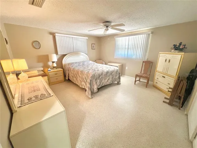 a bedroom with a bed a mirror on dresser and a chandelier