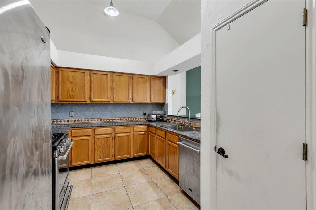 8405 Spinnaker Cove Rowlett, TX 75089 - Photo 12 of 30 a kitchen with stainless steel appliances granite countertop a sink and a refrigerator