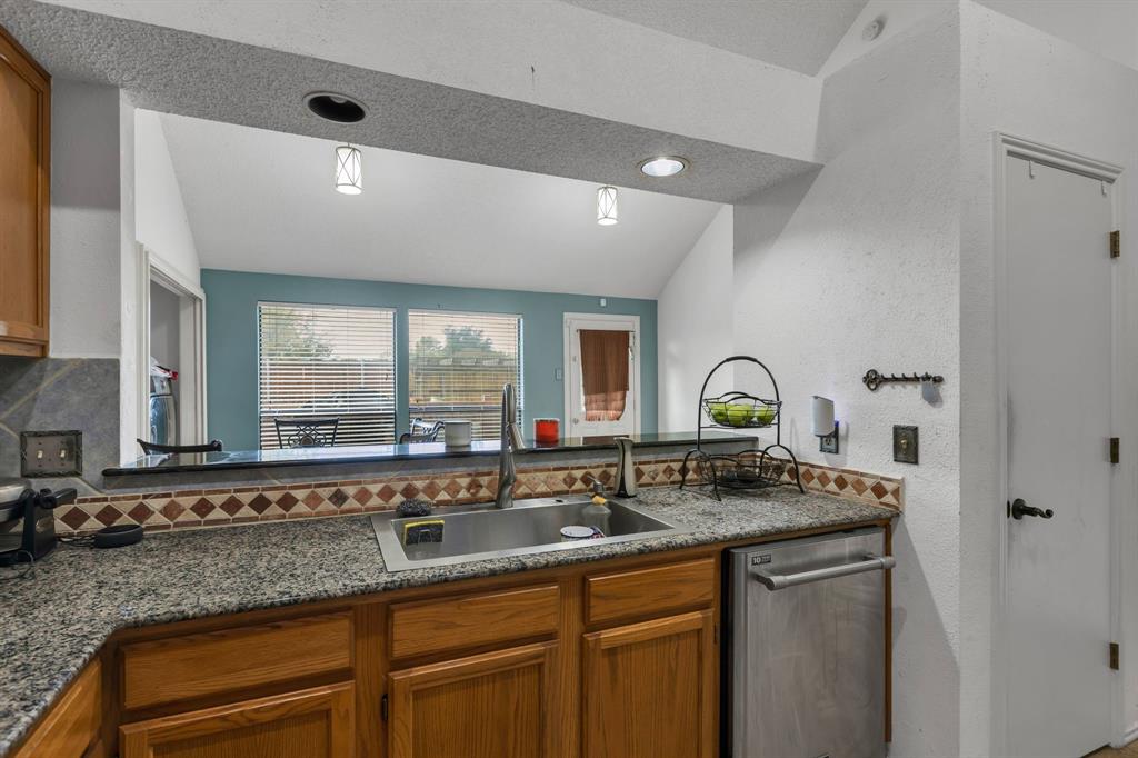 8405 Spinnaker Cove Rowlett, TX 75089 - Photo 14 of 30 a kitchen with granite countertop a sink and a window