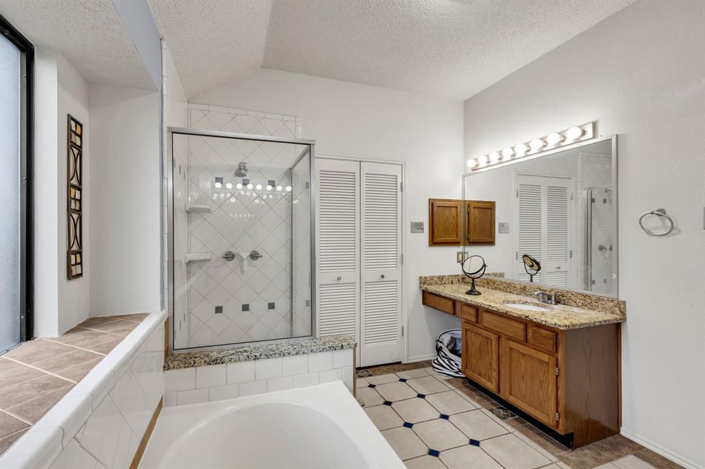 8405 Spinnaker Cove Rowlett, TX 75089 - Photo 22 of 30 a en suite bathroom with a double vanity sink a mirror and a shower