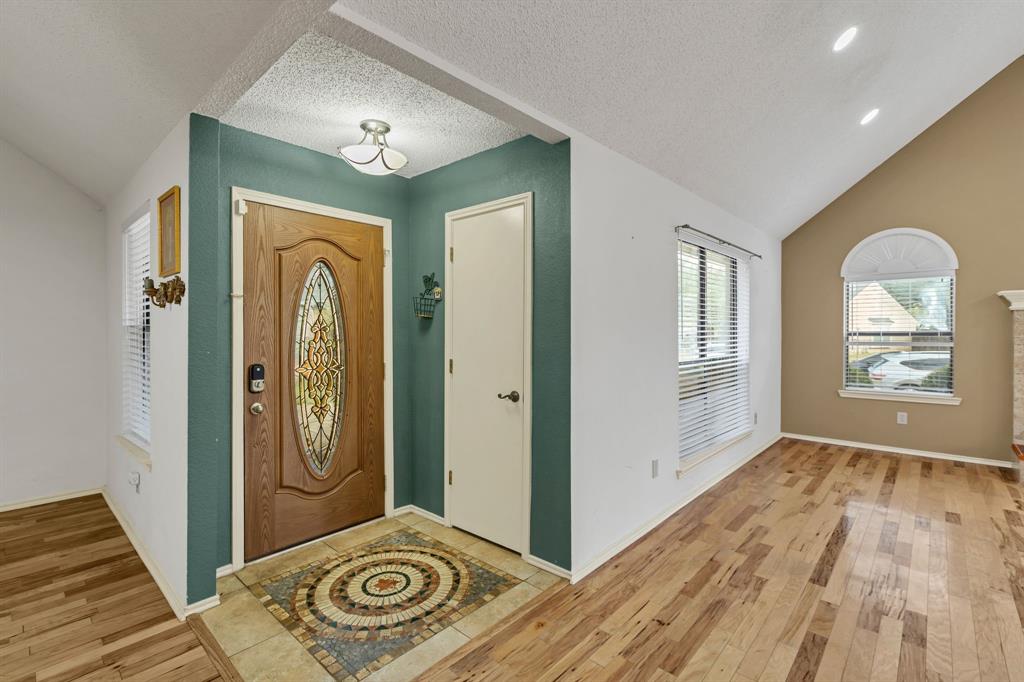 8405 Spinnaker Cove Rowlett, TX 75089 - Photo 6 of 30 a view of a hallway with entryway wooden floor and front door
