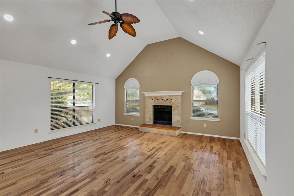 8405 Spinnaker Cove Rowlett, TX 75089 - Photo 7 of 30 an empty room with windows fireplace and wooden floor