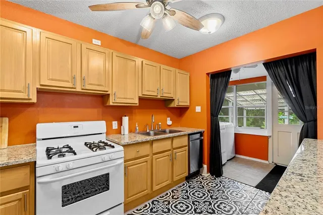 a kitchen with stainless steel appliances granite countertop a stove a sink and dishwasher