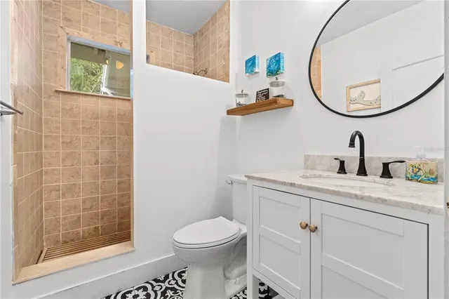 a bathroom with a toilet a sink a mirror and shower