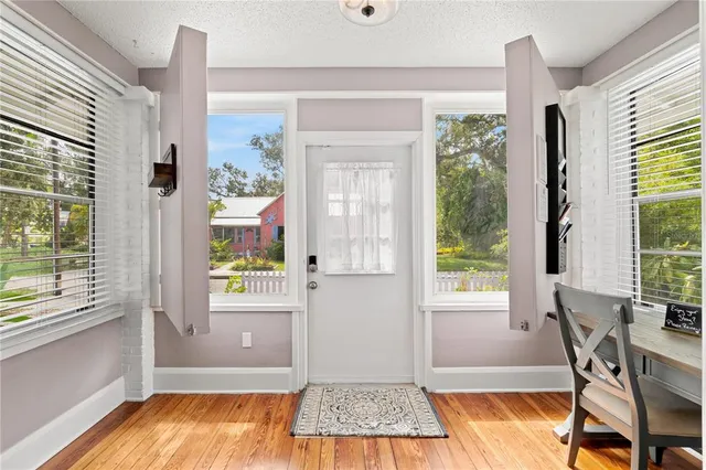 a view of a dining room with a window and wooden floor