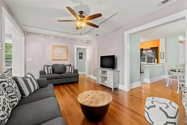 a living room with furniture a flat screen tv and a flat screen tv