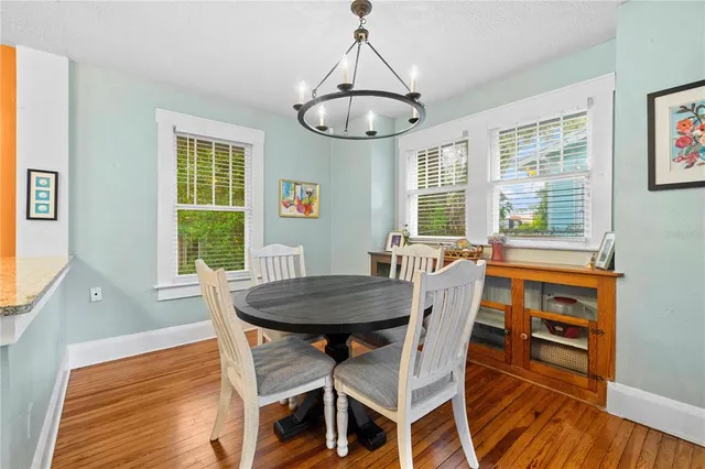 a dining room with furniture a chandelier and wooden floor