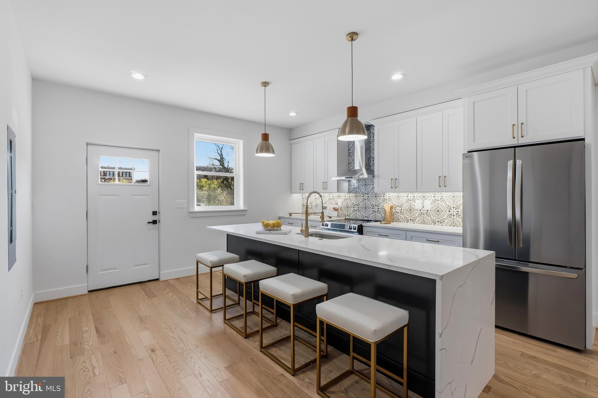 3923 Roland Avenue Baltimore, MD 21211 - Photo 13 of 30 a kitchen with stainless steel appliances a dining table chairs and wooden floor