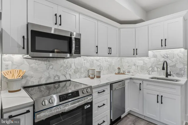 a kitchen with appliances a sink and cabinets