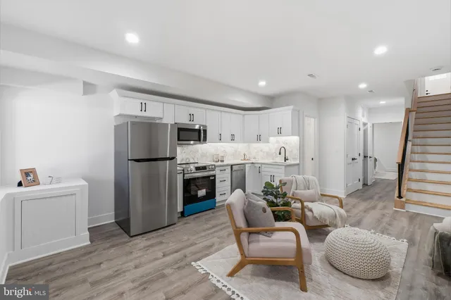 a living room with furniture a refrigerator and a kitchen