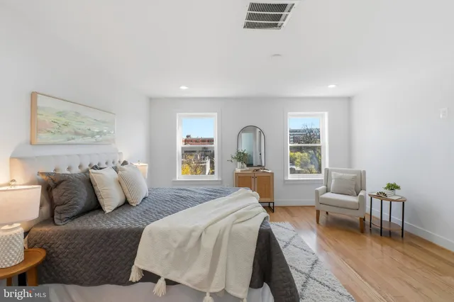 a spacious bedroom with a bed and glass window