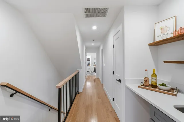 a view of a hallway with wooden floor and staircase