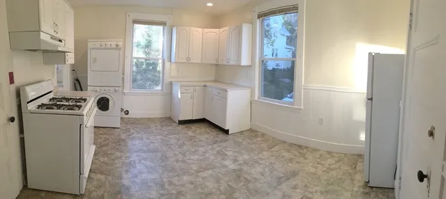 a view of a kitchen with refrigerator and window