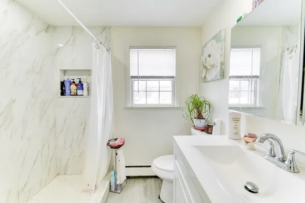 a bathroom with a sink toilet and window