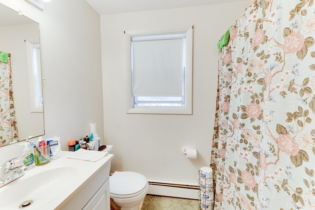 22 Clark Street Randolph, MA 02368 - Photo 12 of 26 a white toilet sitting next to a white sink and a shower curtain