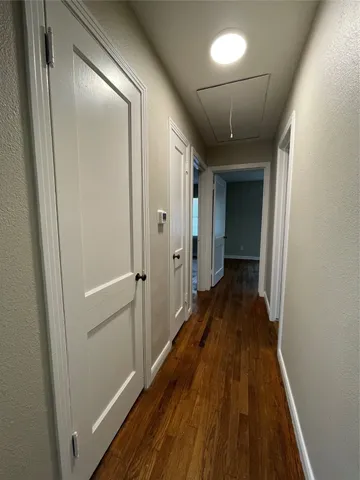 a view of a hallway with wooden floor and staircase