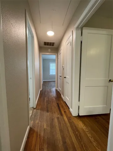 a view of a hallway with wooden floor