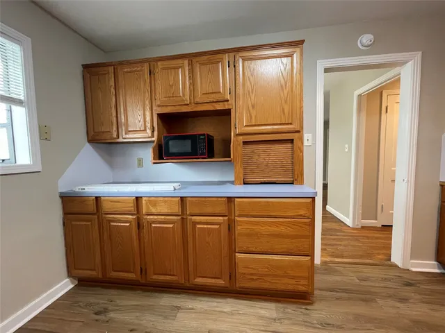 a kitchen with granite countertop wooden cabinets and a fireplace