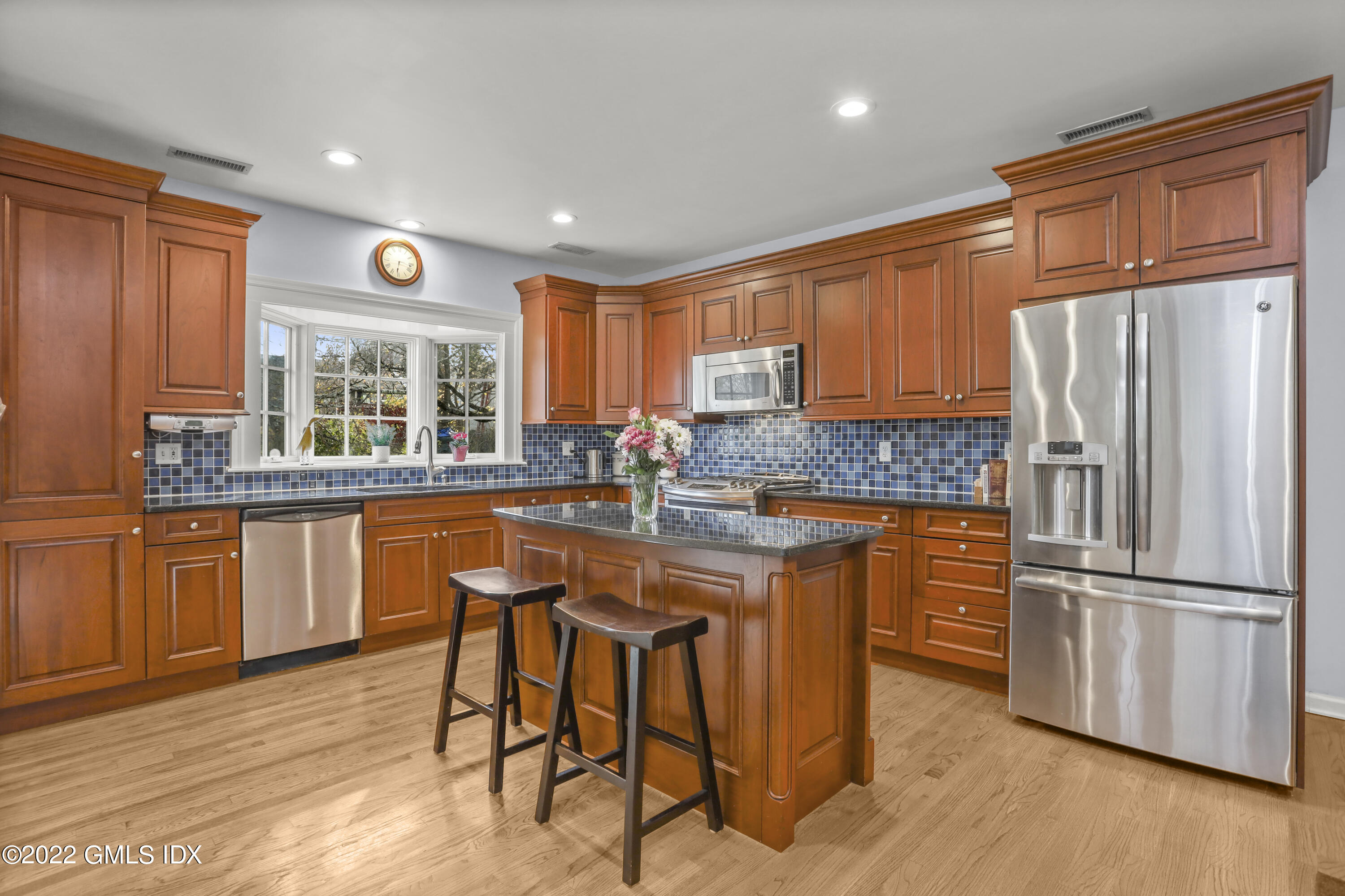 24 Sunshine Avenue Riverside, CT 06878 - Photo 9 of 44 a kitchen with stainless steel appliances granite countertop wooden cabinets a refrigerator a sink a stove a dining table and chairs