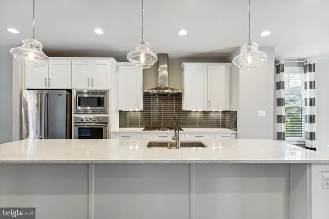 a kitchen with kitchen island a sink stainless steel appliances and cabinets