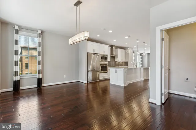 a view of a kitchen with wooden floor and a window