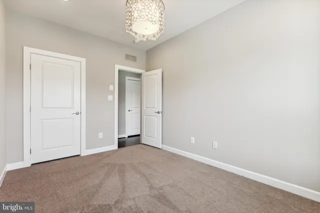 an empty room with a chandelier fan