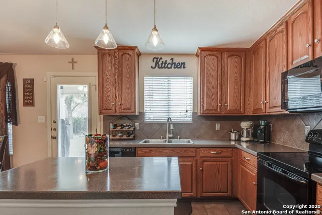a kitchen with stainless steel appliances granite countertop a sink dishwasher stove and cabinets with wooden floor