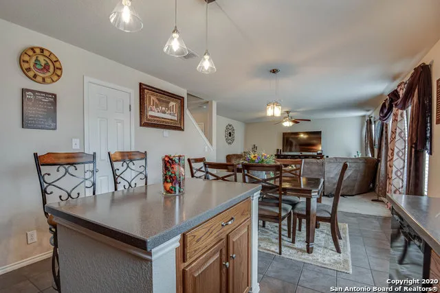 a kitchen with stainless steel appliances granite countertop a table chairs and a refrigerator