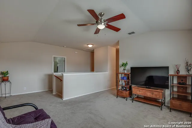 a living room with furniture and a ceiling fan
