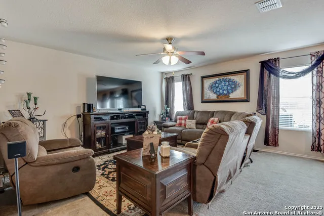 a living room with furniture a large window and a flat screen tv