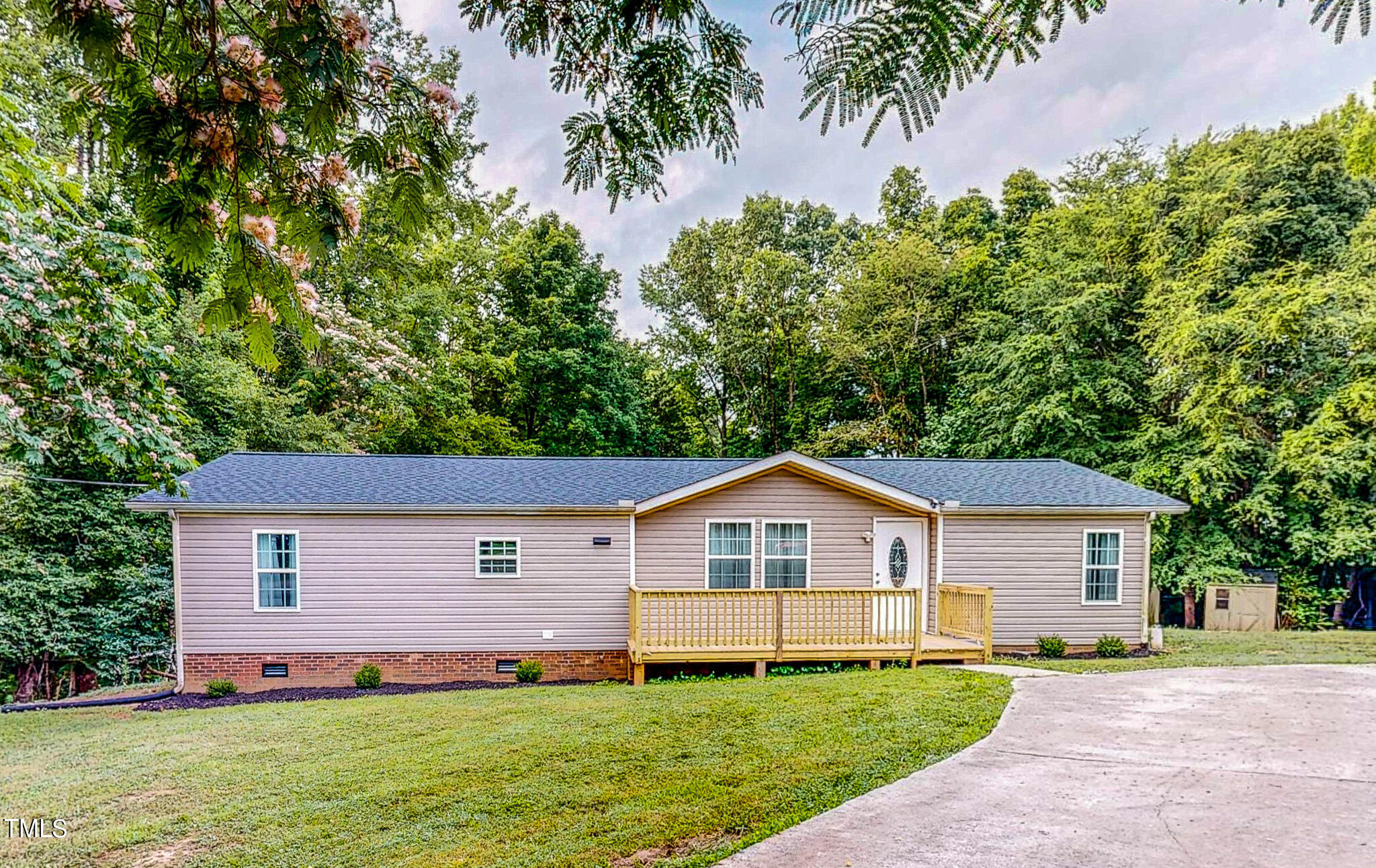 a front view of a house with a yard and trees