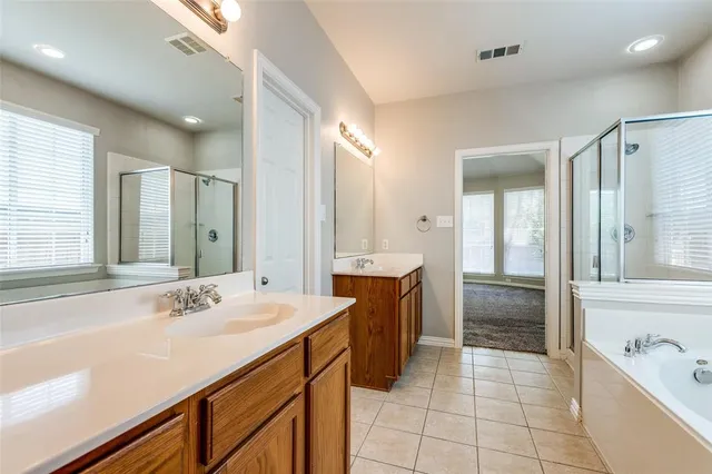 a spacious bathroom with a bathtub sink and mirror