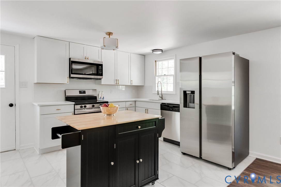 26 Liberty Tree Lane Hanover, VA 23069 - Photo 12 of 38 a kitchen with kitchen island granite countertop a refrigerator a sink a stove a microwave and wooden cabinets