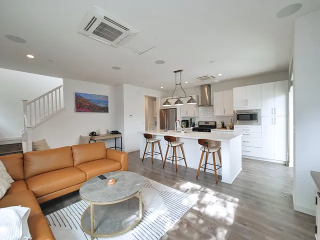a living room with furniture and kitchen view