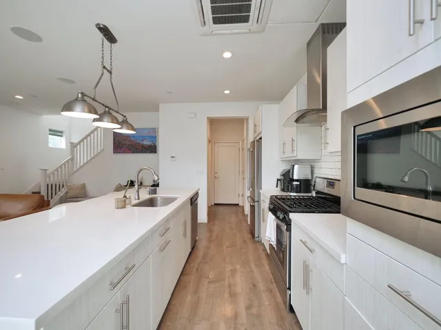 a kitchen with stainless steel appliances a stove sink microwave and cabinets