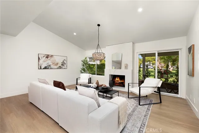 a living room with furniture a fireplace and a chandelier