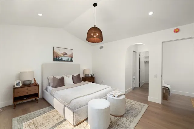 a bedroom with a bed and wooden floor